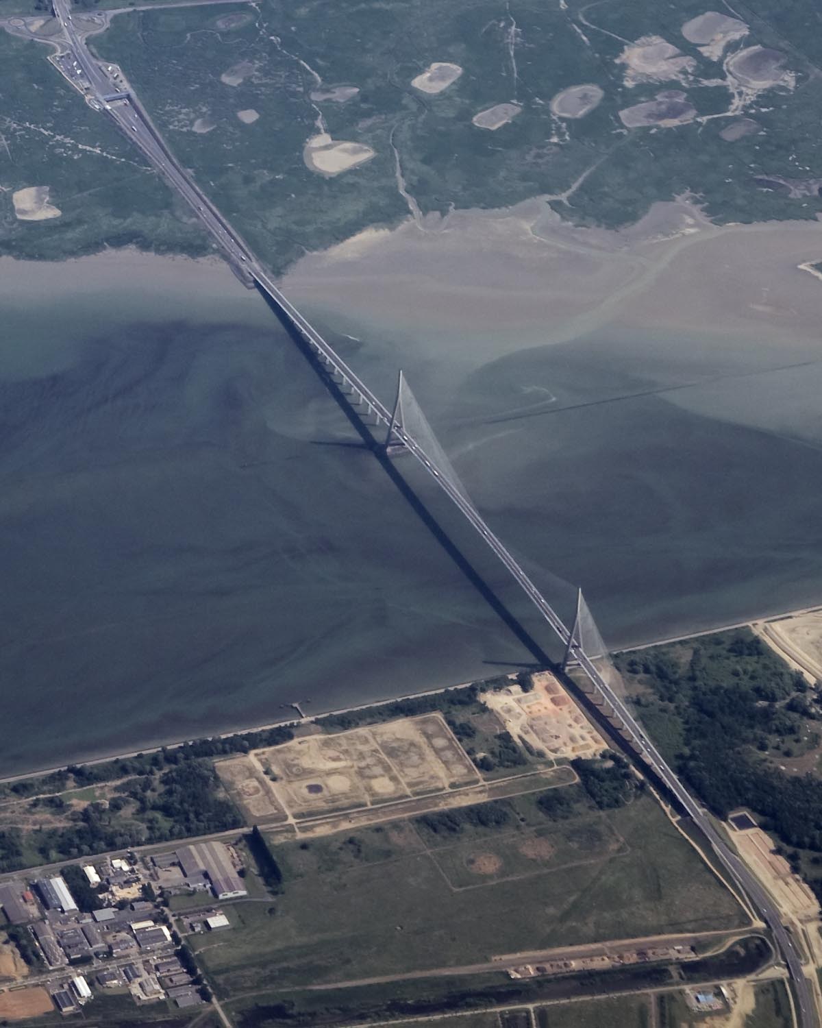 Vue aérienne du pont de Normandie : haubans, estuaire, vasières et terres agricoles.